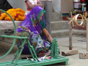 a woman threading yarn at Loom to Luxury